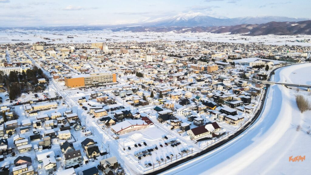 冬の富良野市街地の空撮。相続した不動産や遠方の空き家売却・処分を検討する際に役立つ街並みの様子。
