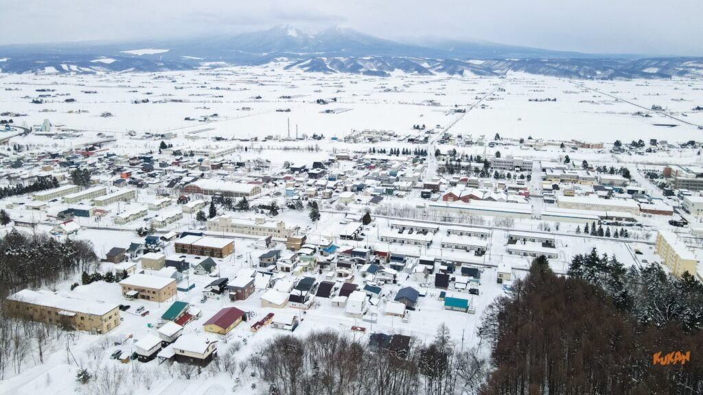 冬の中富良野市街地の空撮。相続した不動産や遠方の空き家売却・処分を検討する際に役立つ街並みの様子。