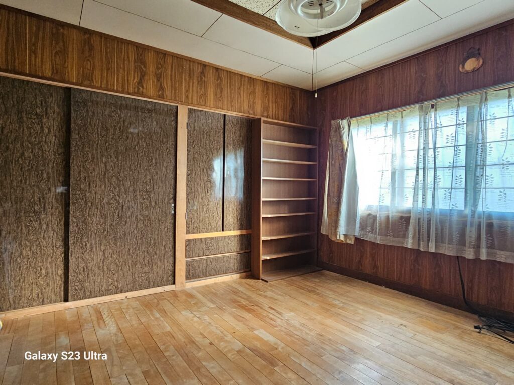 北海道美瑛町にあるリノベーション向けの築古戸建て、木目調の壁と古い引き戸が特徴的な室内。