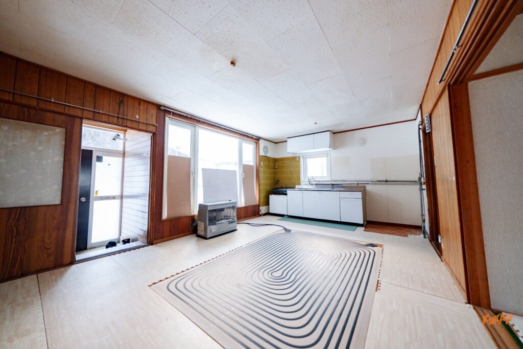 南富良野エリアの不動産投資向け中古戸建てにあるキッチンと木目調の広々とした内装