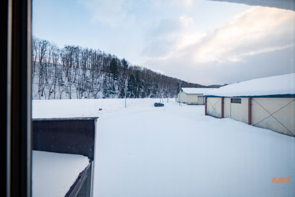 南富良野エリアの不動産投資向け中古戸建ての窓から望む、美しい雪景色と山々の眺望