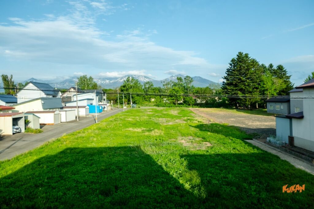 上富良野の社員寮・宿舎向け大型中古戸建てから見渡す、十勝連峰を望む美しい緑の風景