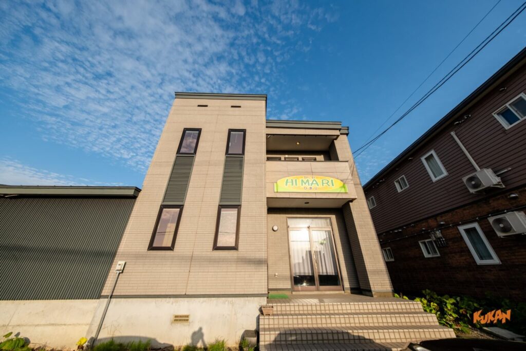 上富良野の社員寮や宿舎に適した大型中古戸建て物件の、広い駐車場を備えた外観