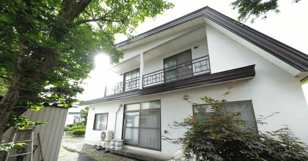 富良野市の中古戸建てを民泊へ再生した、2階建て一軒家の白を基調とした建物外観。
