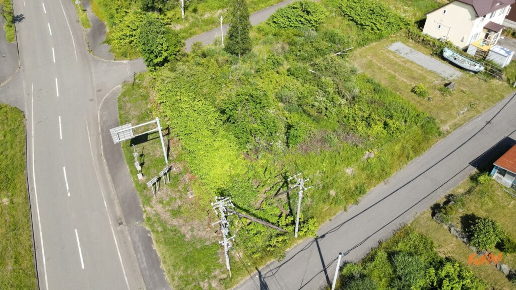 道路と電柱に隣接するホテル許認可・民泊運営向けの洞爺湖エリア投資売地斜め空撮