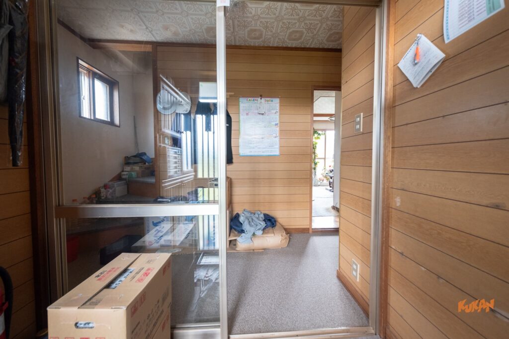 富良野北の峰にある投資用角地戸建ての風除室と玄関ホール。温かみのある木目調の壁と内観廊下。