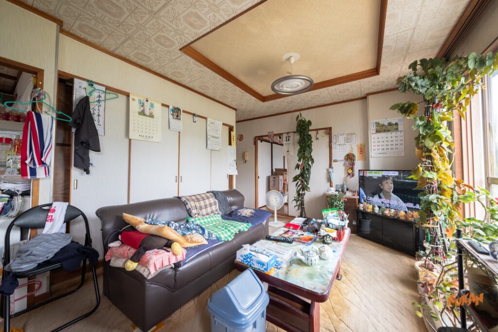 富良野北の峰にある投資用角地戸建てのリビング。ソファーやテレビのある生活感豊かな内観。