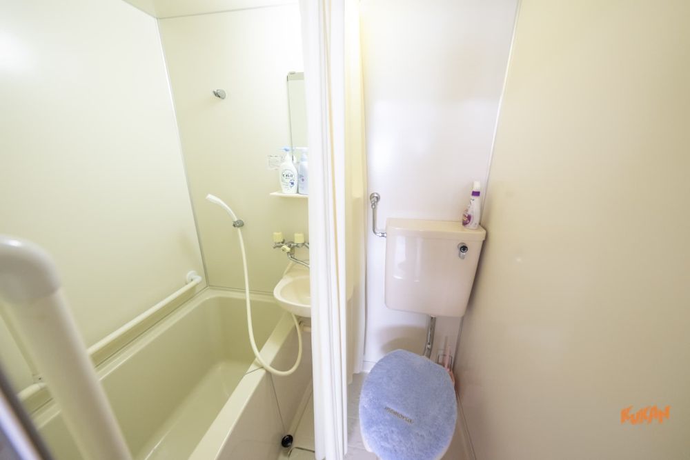 美瑛町のリゾート開発用地物件内にある、浴室とトイレが配置されたコンパクトなユニットバス。