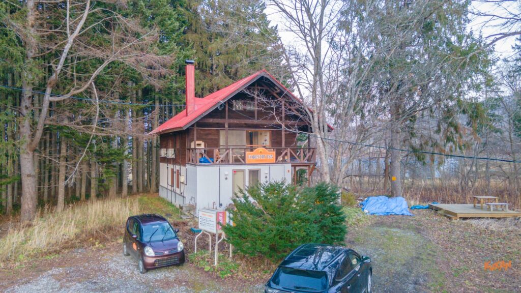 周囲に木々がある中の中古戸建て外観。