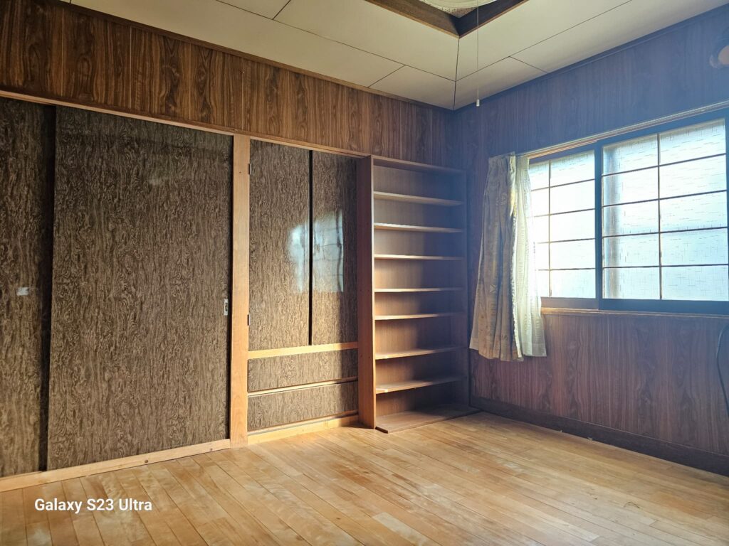 北海道美瑛町にあるリノベーション向けの築古戸建て、木目調の壁と古い引き戸が特徴的な室内。