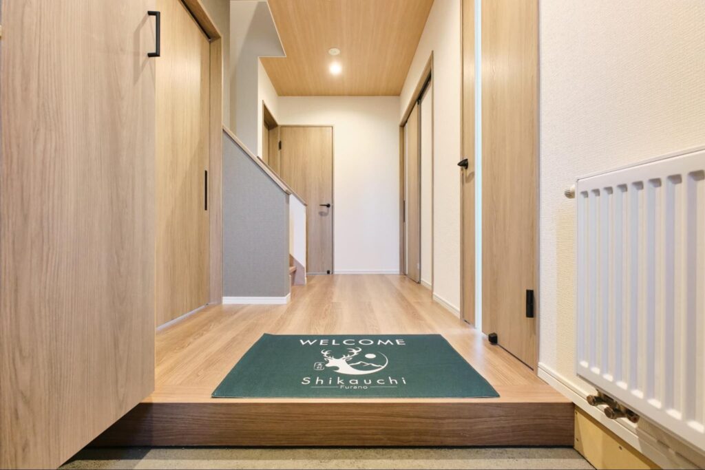 雪景色の中に佇む北海道中富良野の一棟貸し宿泊施設Shikauchiの外観と美しい冬の風景
