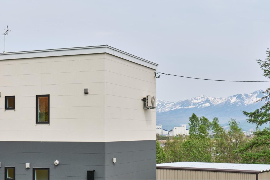 雪景色の中に佇む北海道中富良野の一棟貸し宿泊施設Shikauchiの外観と美しい冬の風景
