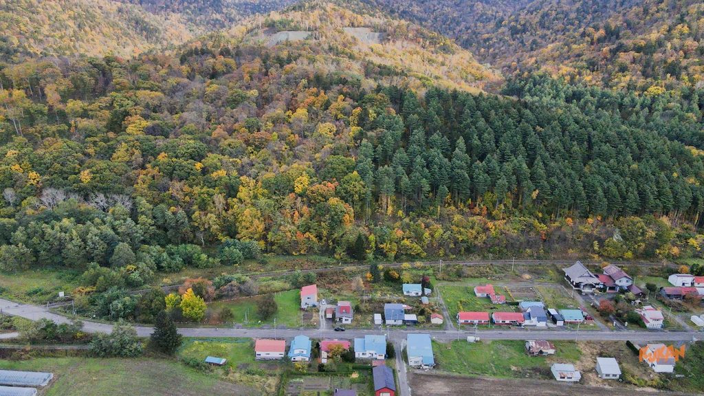 俯瞰富良野布部群山紅葉與村落景象,適合開發三溫暖與度假民宿地產的新蒸餾所進駐區域。
