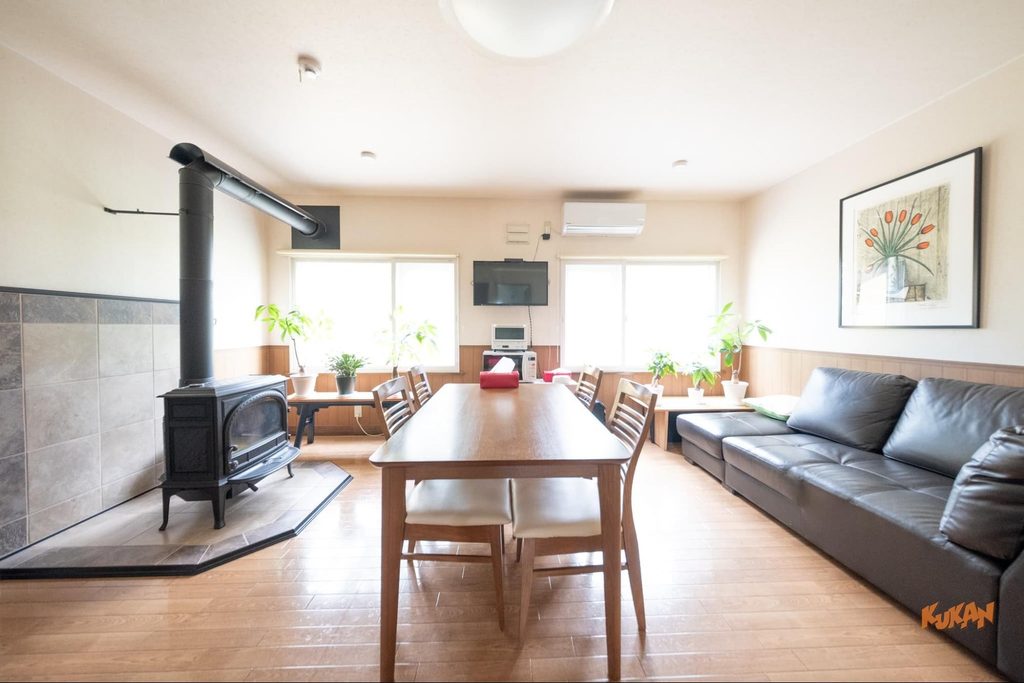Living room with a cozy wood-burning stove on resort development land near Biei's Ken & Mary Tree in Hokkaido